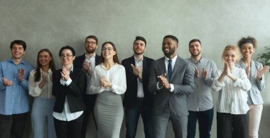 Bir grup iş adamı, patronu tebrik etmek için el çırpıyor. Başarılı bir toplantıdan sonra ayakta alkışlıyorlar.