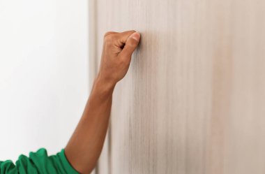 Ahşap kapıyı çalan tanınmayan genç bir kadının yakından görüntüsü girişte duran bir kadın ziyaretçi içeri girmek istiyor, bedava fotokopi alanı, ilk elden seçici odaklanma.