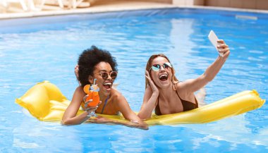 İki mutlu milenyum kızı yaz tatilinde bilardoda selfie çekiyor.