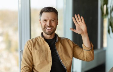 Modern Ofiste Oturan Kameraya Gülümseyen Neşeli İş Adamı. Girişimci Adam Çevrimiçi Hareketleriyle İş yerinde Selam Veriyor. İş İletişim İstihdamı