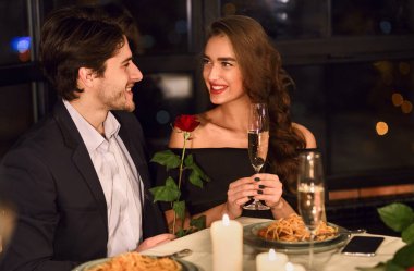 Gül gülümseyen ve söz tutan iki Restoran, şampanya, içme kadın yemeğe aşık adam