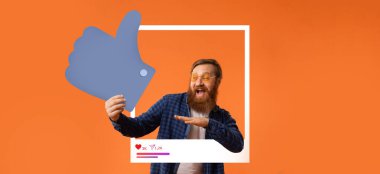 Sakallı ve gözlüklü bir adam, çevrimiçi izleyicisiyle ilgilenirken başarısını başparmak işareti yaparak kutluyor. Parlak turuncu arka plan onun neşeli ifadesini arttırır..