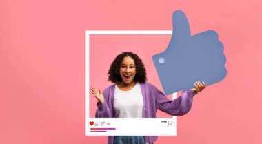 Genç bir nüfuzlu kişi, sosyal medyada olumlu katılımı kutlamak için büyük bir olumlu sembol ile coşkuyla poz veriyor. Hayat dolu arka plan neşeli atmosfere katkı yapıyor..