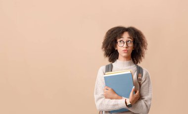 Seçim yapın ya da çalışmayı düşünün. Karantinadan sonra eğitimde sorun yaşayın. Sırt çantalı, gözlüklü Afro-Amerikan bayan öğrenci elinde not defterleriyle boş alana bakıyor.