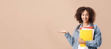 Okul, üniversite ve enstitü için modern öğrencilerin seçilmesi önerildi. Sırt çantası ve defterleriyle gülümseyen Afrikalı Amerikalı kadın boş bir yeri işaret ediyor ve kameraya bakıyor, sarı arka plan.