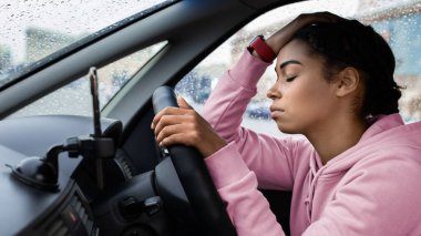 Müşteri aramasını beklemek, trafik sıkışıklığında durmak ve yolda durmak, yine mi? Binlerce yıllık yorgun Afro-Amerikan kadın gözleri kapalı direksiyona yaslanıyor ve hareket için bekliyor, kopyalama alanı