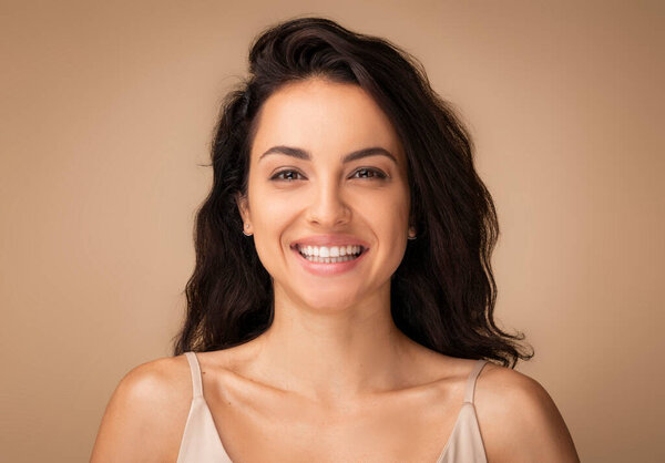 "Timeless Beauty Portrait of Young Brunette Woman". Крупный план молодой красивой девушки, ее лицо купается в мягком освещении, источая ауру вечной элегантности и уверенности. Концепция ухода за кожей