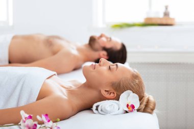 Spa Resort 'ta balayı. Aromaterapi sırasında havluya sarılmış rahat bir çift içeride dinleniyor, gözleri kapalı. Rahatlama, romantik spa günü ve güzellik tedavisi. Seçici Odaklanma