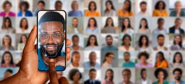 Bir insan akıllı telefonu elinde tutar, yüzünü taramak için yüz tanıma teknolojisini kullanır..