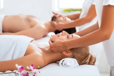 Rahatlamış eşler yüz masajı yaptırıyor. Yataklara uzanıyor, Beyaz Havlulara sarılıyor. Otel Spa 'da. Yenilenme, Rahatlama ve Sağlık Konsepti. Seçici Odaklanma