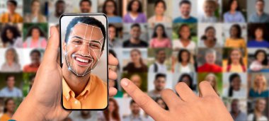 Bir el, yüz tanıma arayüzü gösteren bir akıllı telefonu tutuyor. Arka planda, modern kimlik teknolojisini gösteren birden fazla insan portresi görülebilir..