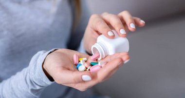İntihar konsepti. Umutsuz genç bir kadın kavanozdan bir avuç dolusu hap dolduruyor, yakın plan. Binlerce yıllık depresyondaki bir kadının aşırı dozda ilaç alarak kendini öldürmesi.