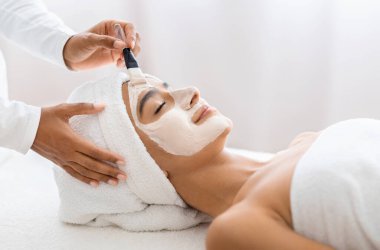 Sükunet anında, genç Hintli kadın profesyonel bir yüz maskesi tedavisinin lüksünü yaşıyor, cildinin parlaklığını arttırıyor. Kaplıcada gün, güzellik tedavisi