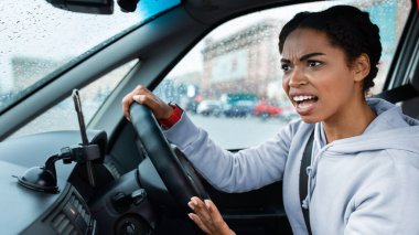Çatışma, kaza ve tehlikeli yol durumu. Kızgın, agresif, bin yıllık Afro-Amerikan kadın direksiyon tutuyor ve başka bir sürücüye küfrediyor.