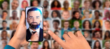 Bir el, dijital yüz tanıma çizgileri olan bir adamın yüzünü gösteren bir akıllı telefonu tutuyor..