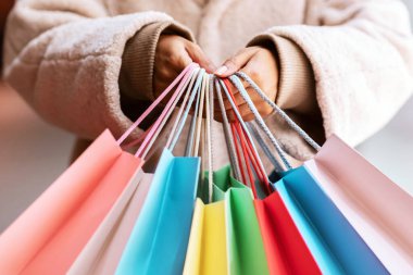 Alışveriş Seri Konsepti. Tanımlanamayan Afro-Amerikan bayanın bir sürü renkli çanta tutup kameraya göstermesi. Satın alma ve hediye taşıyan siyah bir kadın. Perakende ve Satış