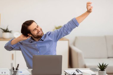 Kollarını uzatan ve masaj yapan bir adam işten sonra bilgisayarın başında modern ofiste oturan yorgun boyuna masaj yapıyor. Sağlık sorunu, Boyun ve Omuz Gerginliği Konsepti