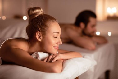 Eşler Masaj Terapisi 'nden sonra dinleniyor. Lüks Spa Oteli' nde gözleri kapalı yatıyorlar. Aromaterapi, Güzellik, Sağlık ve Rahatlama Tedavisi Konsepti. Düşük Işık, Seçici Odaklanma