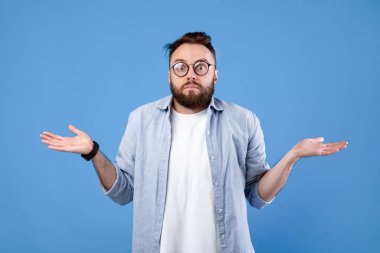 Kim bilir? Mavi stüdyo arka planında omuz silken gözlüklü kafası karışmış sakallı bir adam. Emin olmayan bin yıllık adam belirsizliğini dile getiriyor, bilgisiz hissediyor, zor seçimler yapıyor.