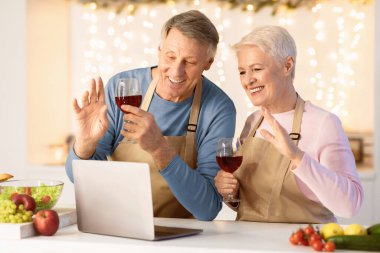 Sanal Noel Partisi. Yaşlı bir çift, Xmas 'ı kutlarken, dizüstü bilgisayarda şarap içerken, uzaktan kumandalı aile ve arkadaşlarıyla evde otururken görüntülü konuşma yapıyor. Tatil Kutlaması