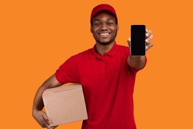 Gülümseyen Sakallı Afrikalı Amerikalı Teslimatçı Boş Kara Ekran Tutma Kutusuyla Akıllı Telefon Gösteriyor Posta Ekspres Nakliye Uygulaması Sarı Stüdyo Arkaplanı Üzerinde İzole Edildi