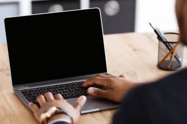 Tanımlanamayan siyahi işadamı, küçük, modern bir klavyeye boş ekranla yazı yazıyor. Ofisinde çalışan Afrikalı bir Amerikalı yönetici, online Webinar 'a katılıyor ya da eğitim yapıyor.