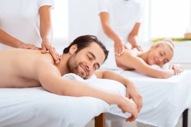 Rahatlamış koca ve eş sırt masajı alırken vücut dinlenme terapisi sırasında yatakta yatarken, gözleri kapalıyken. Lüks Spa Servisi Reklamları, Güzellik ve Sağlık. Seçici Odaklanma