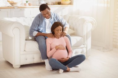 Bakıcı koca, hamile karısına masaj yapıyor, evinde omuzlarına masaj yapıyor, fotokopi çekiyor. Hamilelik sırasında gerilimi azaltmak için güzel kız arkadaşına masaj yapan Afrikalı Amerikalı bir adam.