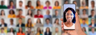 Bir el, kimlik belirlemek için dijital bir örtüyle gülümseyen bir yüzü gösteren bir akıllı telefonu tutar..