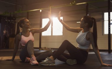 Başarılı bir eğitim. Beşlik çakan kadınlar, spor salonunda dinlenenkadınlar