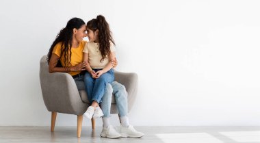 Mother And Child Bonding. Loving Young Mom And Little Daughter Embracing While Relaxing In Armchair At Home, Happy Middle Eastern Family Enjoying Spending Time Together, Panorama With Copy Space