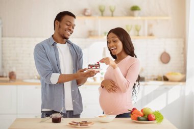 Yakışıklı siyah adam, hamile karısını mutfakta lezzetli bir pastayla baştan çıkarıyor. Afrika kökenli Amerikalı koca, müstakbel kız arkadaşına tatlı ikram ediyor. Hamilelik boyunca sağlıksız beslenme
