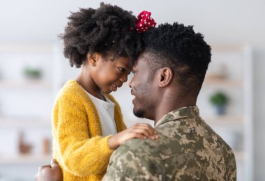 Siyah, şirin, asker babasıyla kucaklaşan küçük bir kızın portresi, Afrikalı, Amerikalı, üniformalı, kızına sarılan, evinde, yakın görüntüsünde, kız çocuğuyla bağ kuran,