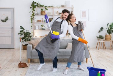 Harika bir ev temizliği ve rock grubu. Neşeli koca süpürgeyle oynar, önlüklü kadın hayali mikrofonda şarkı söyler paspasla, modern oturma odasının içinde temizlik malzemeleriyle, boş alanla