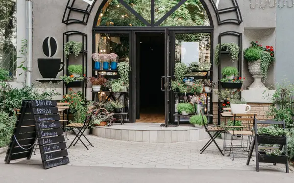 Sokak ve çiçek stüdyosundaki Eko kafe, şehirde küçük bir işletme, Coperid-19 'dan sonra tekrar açılıyor, iç mekan. Menü tahtası, müşteriler için masalar, modern mağazada raflarda saksı bitkileri, hiç kimse