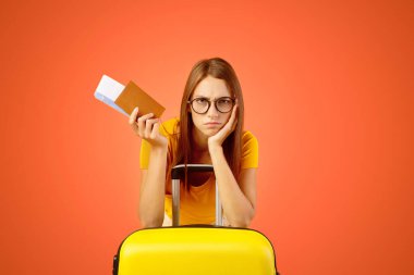 Pasaportu ve uçak biletleri olan üzgün genç bir kadın, COVID-19 yüzünden tatilini kaçırdı. Karantina ve seyahat konsepti. Üzgün kadın salgın yüzünden evde kalıyor.