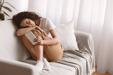 Akıllı telefonlu yalnız bir kadın evdeki koltukta oturmuş sevgilisinden mesaj bekliyor, fotokopi odası. Üzgün genç bayan cep telefonu ekranına bakıyor, depresyon geçiriyor, oturma odası içi...