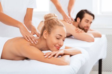 Çift Masajı. Rahatlamış eşler prosedürün tadını çıkarıyorlar. Kapalı kaplıcadaki kaplıcada masör koltuğunda uzanıyorlar, gözleri kapalı. İki Kişilik Romantik Güzellik Tedavisi, Masaj Terapisi. Seçici Odaklanma