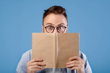 Gözlüklü genç adam kitap okurken şok oldu. Mavi stüdyo geçmişine şaşırarak gözlerini açtı. Şaşırmış okuyucu ders kitabına takılıp kalmış, heyecan verici bilgiler buluyor, ilginç bir şey öğreniyor.
