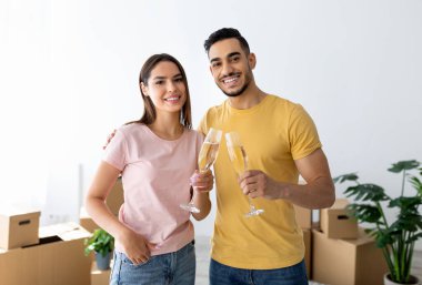 Irklar arası eşlerin taşınma gününü şampanyayla kutlaması, yeni dairede karton kutuların arasında kadeh kaldırması. Mutlu milenyum çifti kendi evlerine taşınıyor.