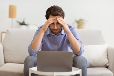 Laptop 'ın başındaki endişeli iş adamı içeride koltukta otururken iş sorunu yaşıyor. Bilgisayar Sorunu, İşsizlik ve Uzak Çalışma Depresyonu, İşletme Başarısızlığı ve İflas Konsepti