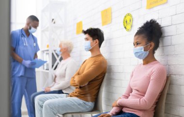 Coronavirus aşısı. Covid-19 aşısını bekleyen çeşitli hastalar hastane bekleme odasında kuyrukta bekliyor. Corona Virüs Önleme, Tıbbi Bağışıklık Kampanyası. Seçici Odaklanma