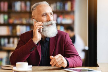Kafede kahve içerken cep telefonuyla konuşan, fotokopi çeken yaşlı bir işadamı. Takım elbiseli yaşlı yakışıklı sakallı adam dinlenme odasında ya da kafede dijital tabletle vakit geçiriyor.