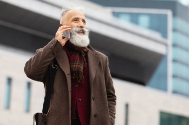Zengin, yaşlı, kır saçlı, uzun sakallı bir adam sokakta yürürken cep telefonuyla konuşuyor, iş merkezine gidiyor, iş toplantılarına gidiyor, boş alanlara bakıyor.