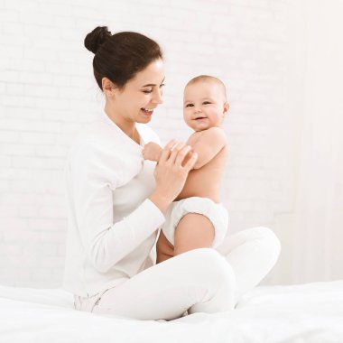 Annelik günlerin kutlu olsun. Genç anne kucağında küçük bebeğiyle, boş bir panorama