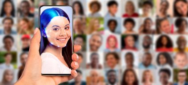Yüz tanıma özellikleri olan bir kadının yüzünü gösteren akıllı telefonu tutan bir el. Arkasında, çeşitli portrelerden oluşan bir kolaj modern kimlik teknolojisini kullanımda vurguluyor.