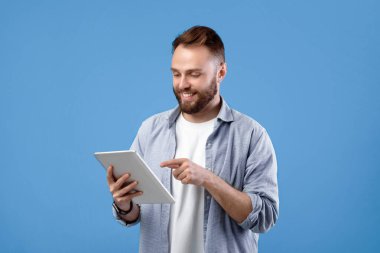 İnternet işi için tablet bilgisayar kullanan neşeli sakallı bir adam ya da mavi stüdyo geçmişi üzerine çalışmalar yapan. Pozitif öğretmen uzaktan ders veriyor. Sosyal ağ için yeni bir gönderi oluşturan blogger