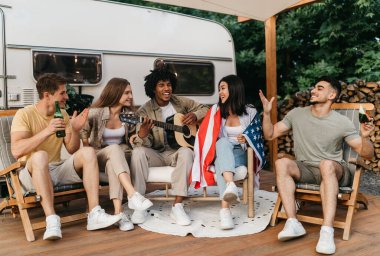 Neşeli ırklar arası arkadaşlar gitar çalıyor, şarkı söylüyorlar, Amerikan bayrağı tutuyorlar, bira içiyorlar, karavanın yanında oturuyorlar, Bağımsızlık Günü 'nü kutluyorlar, yaz tatilinde kamp yapıyorlar.