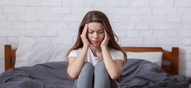Mutlu olmayan milenyum bayanı yatakta oturuyor ve şakaklarına masaj yapıyor, baş ağrısı ya da depresyon geçiriyor. Uykusuzluk çeken yorgun genç bir kadın, olumsuz düşüncelerle boğulmuş.
