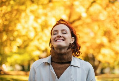 Kafkasya 'nın bin yıllık kızıl saçlı, yağmurluklu dişisi sıcak bir sonbahar ve özgürlüğün tadını çıkarıyor. Parkta sarı yapraklarla temiz hava soluyor. Covid-19 karantinasının sonunda şehirde tek başına dinlen ve dinlen.